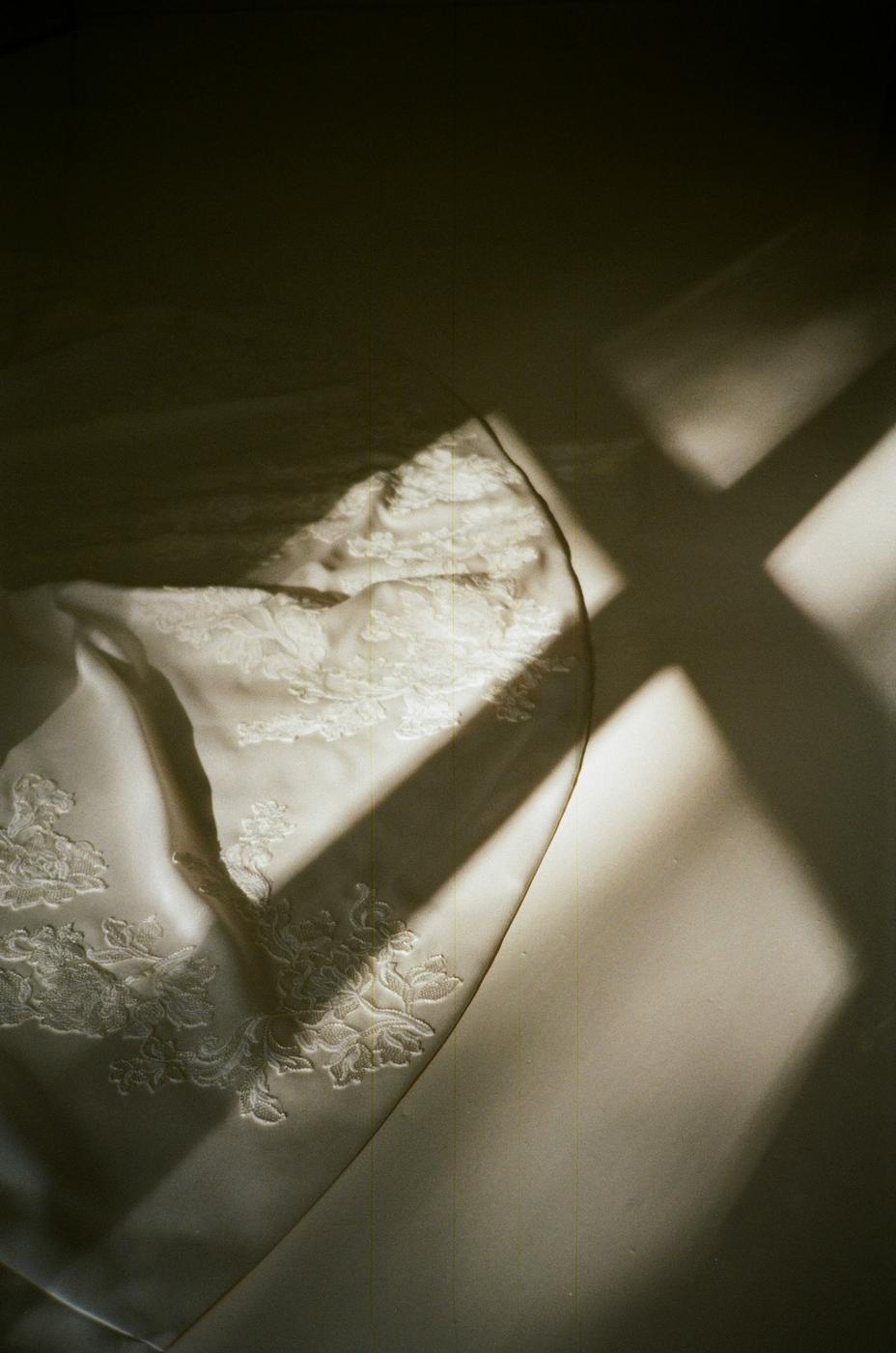 Lace on a wedding dress, crossed by window light and shadow