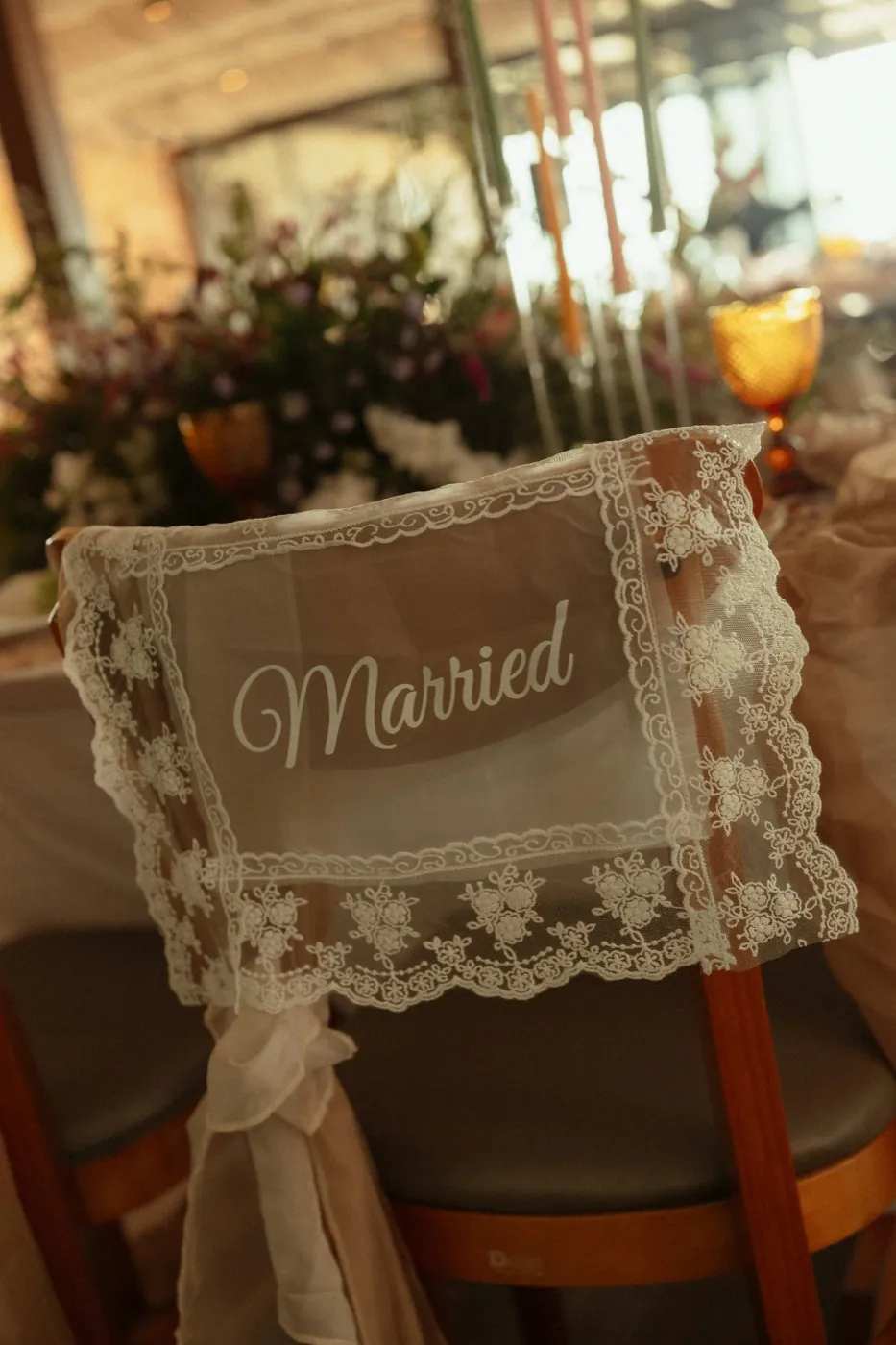 A lace Married sign tied to a wooden chair at the reception
